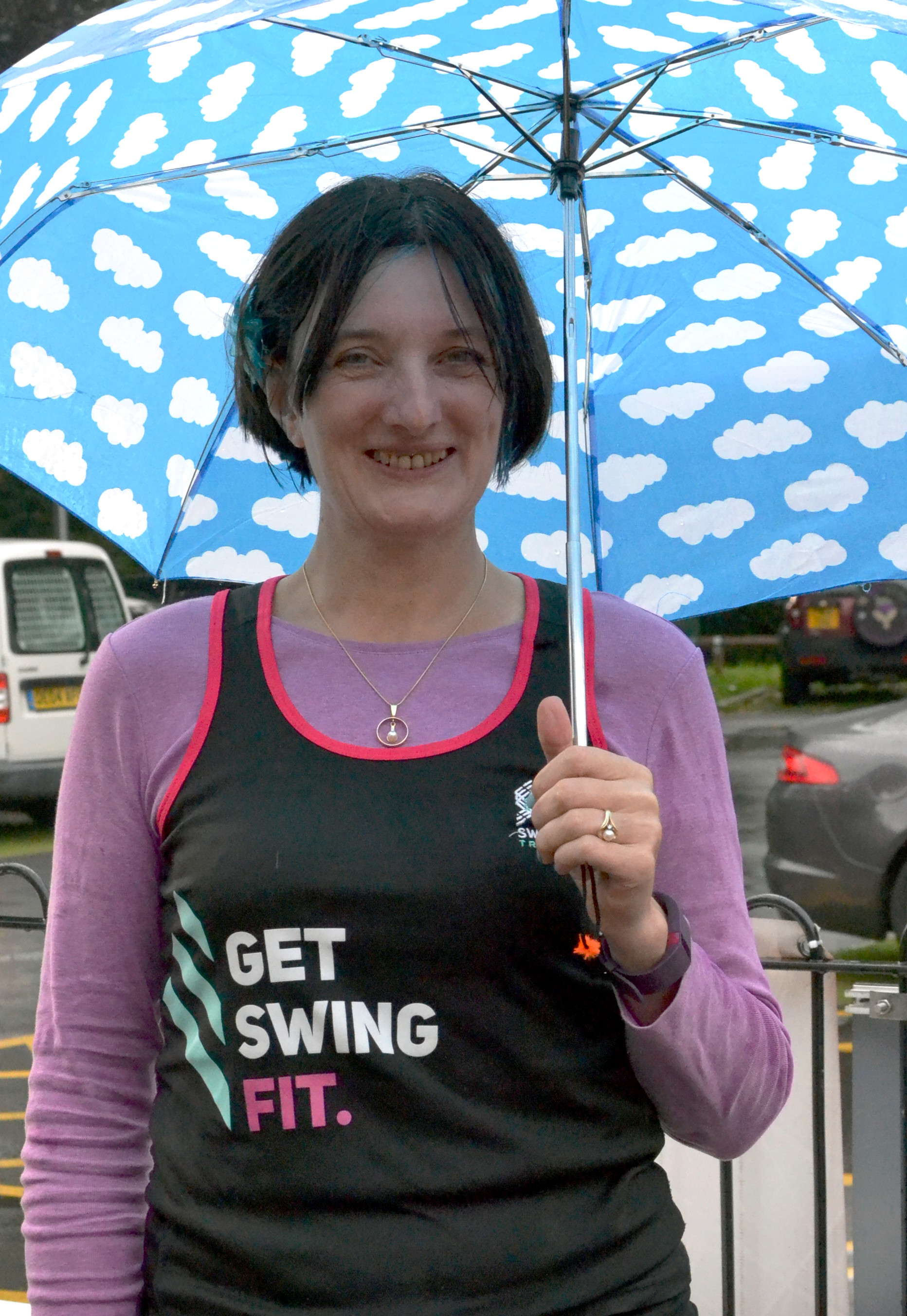 Carola of Swing Fit smiling under an umbrella