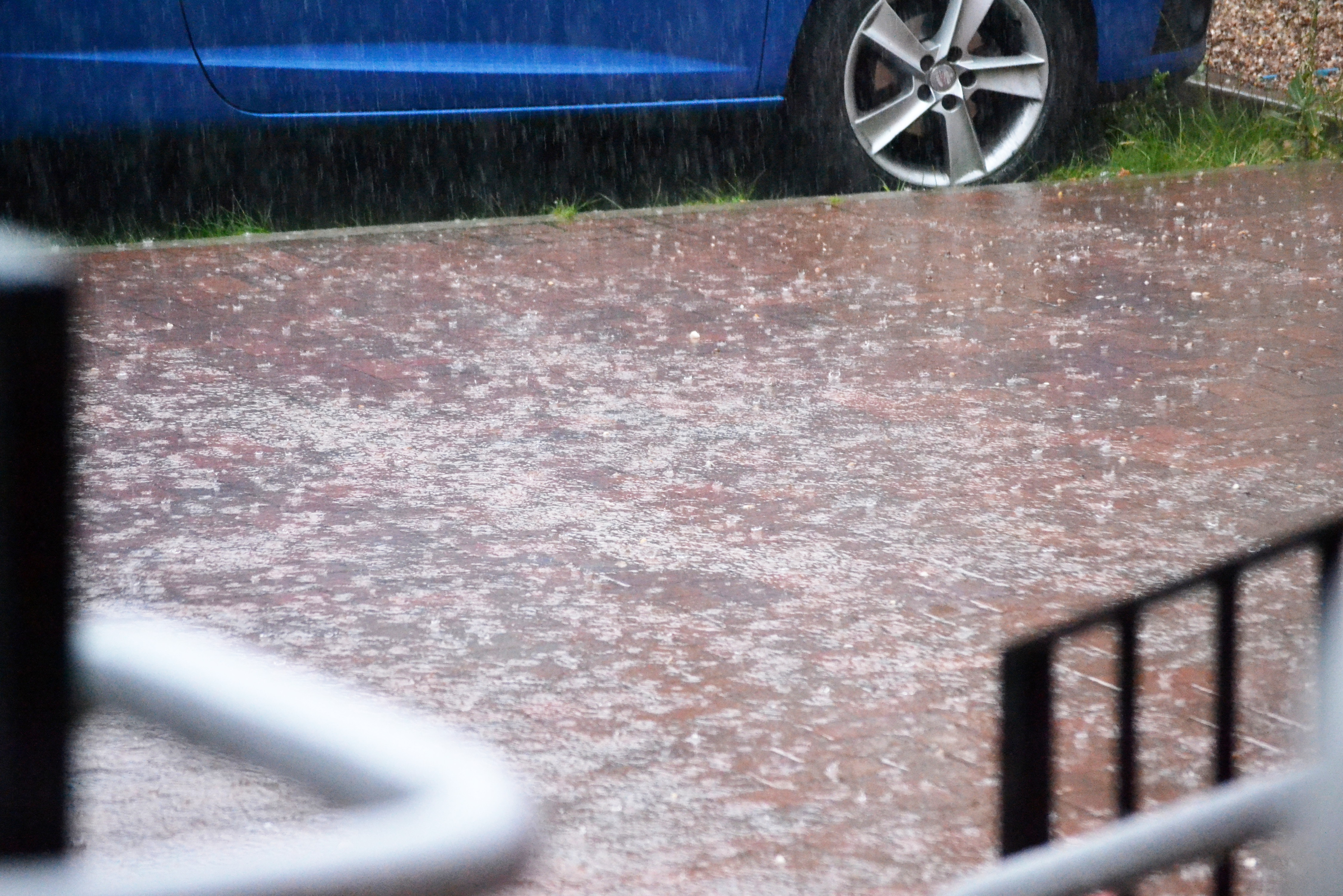 Heavy rain falls on the pavement outside Stirchley Baths