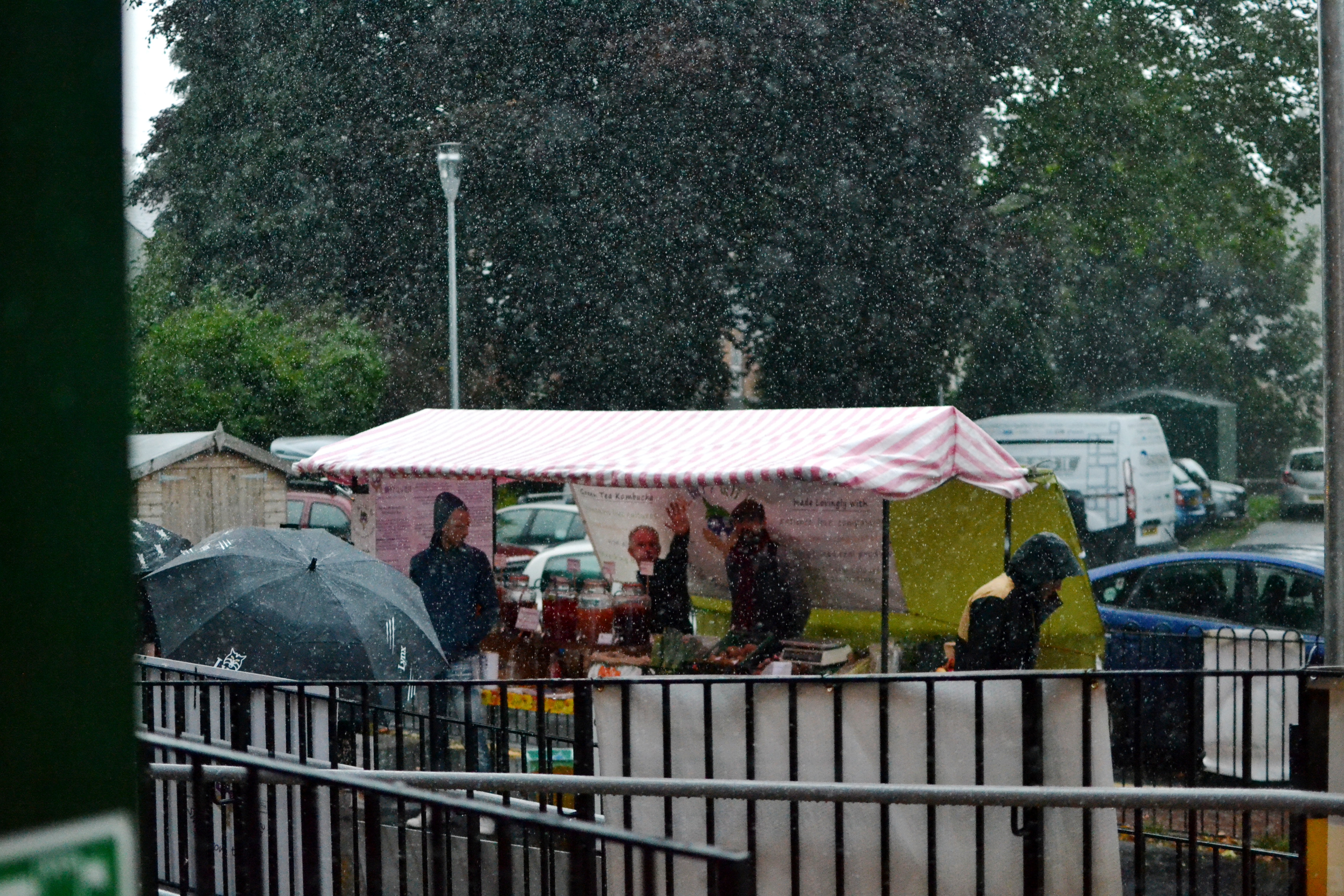 Heavy rain falls on the outside Market stall and an umbrella
