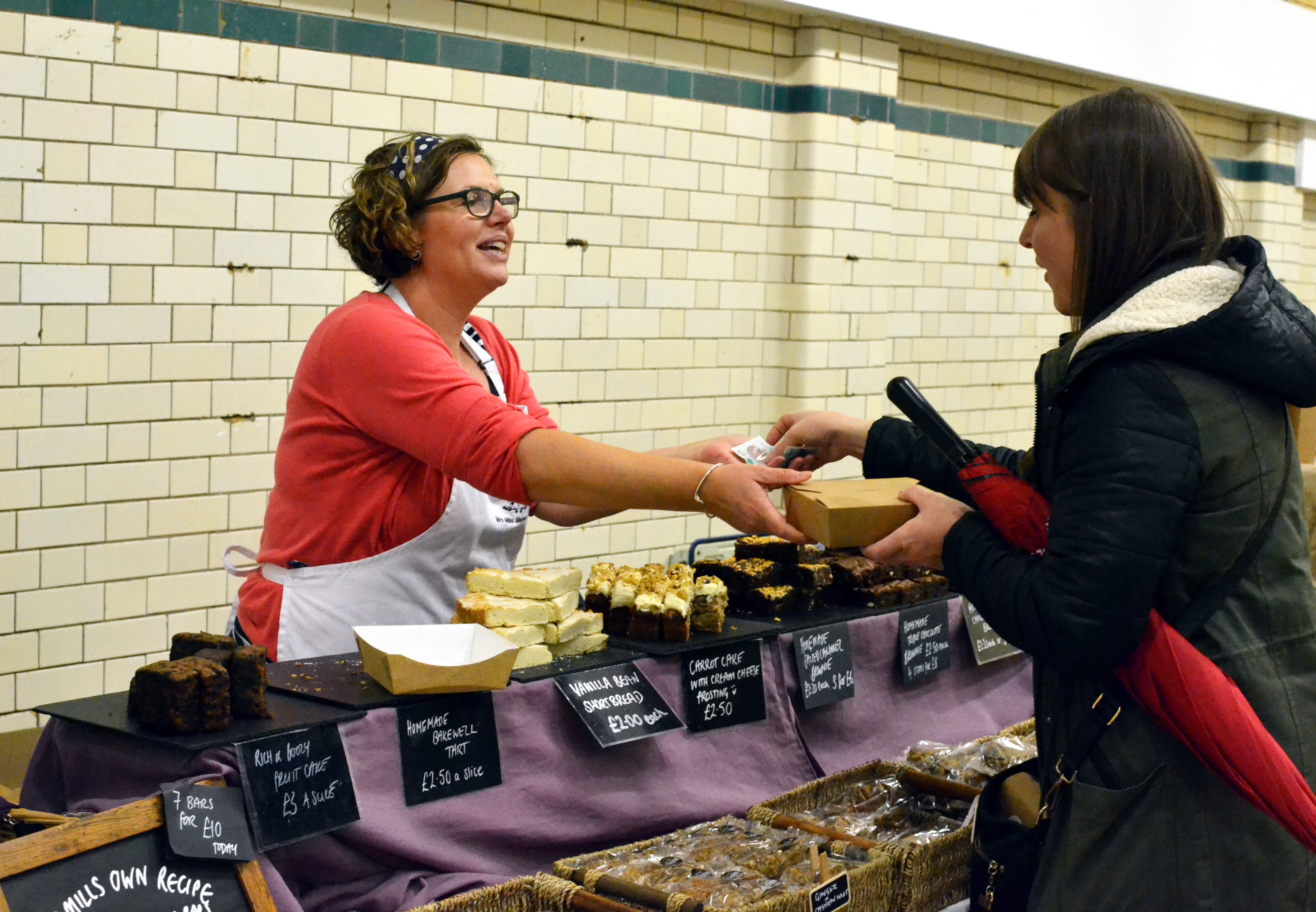 A customer buying from Mrs Mills Makes Cakes