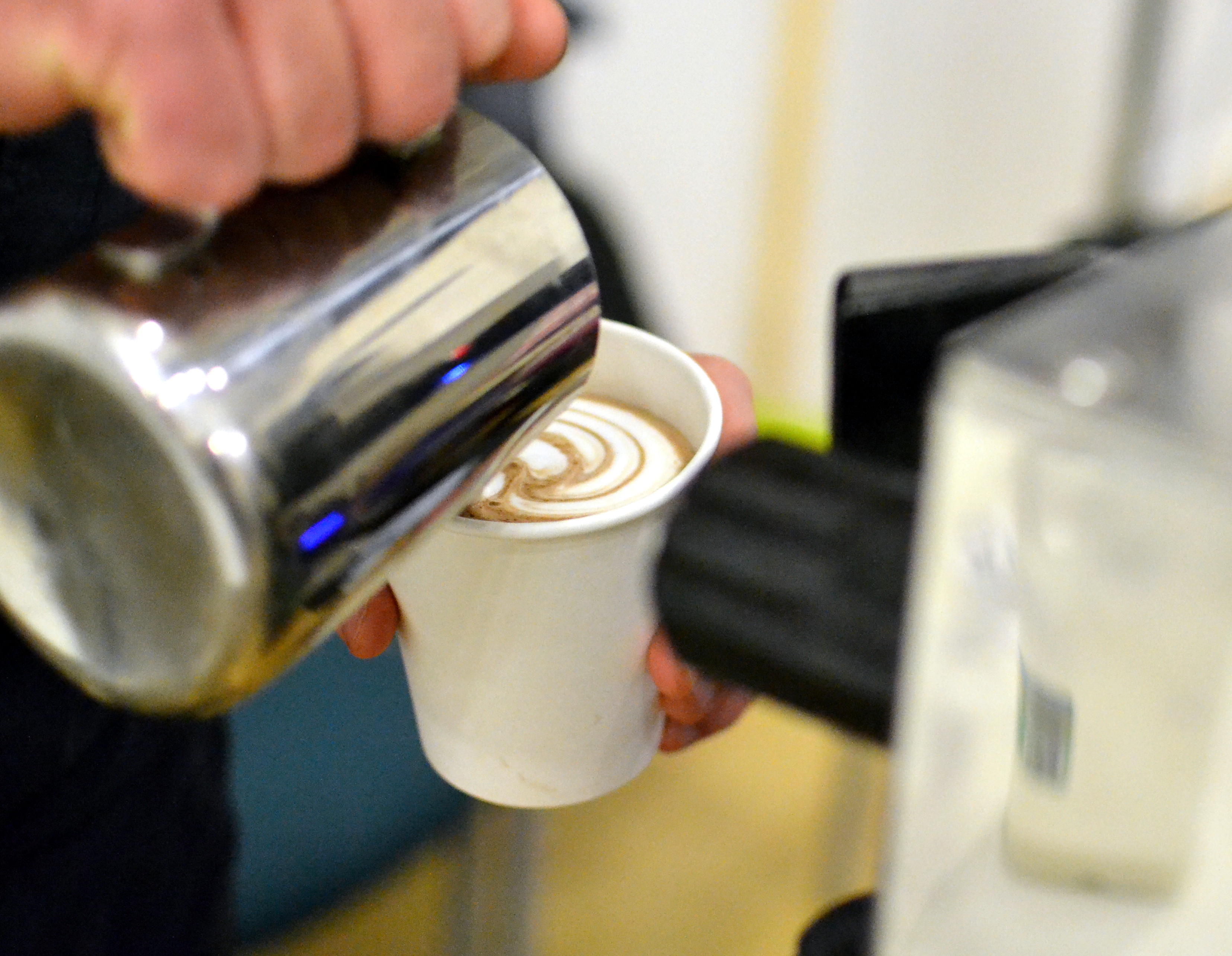 Adding a swirl of milk to a hot drink on the There Goes stall