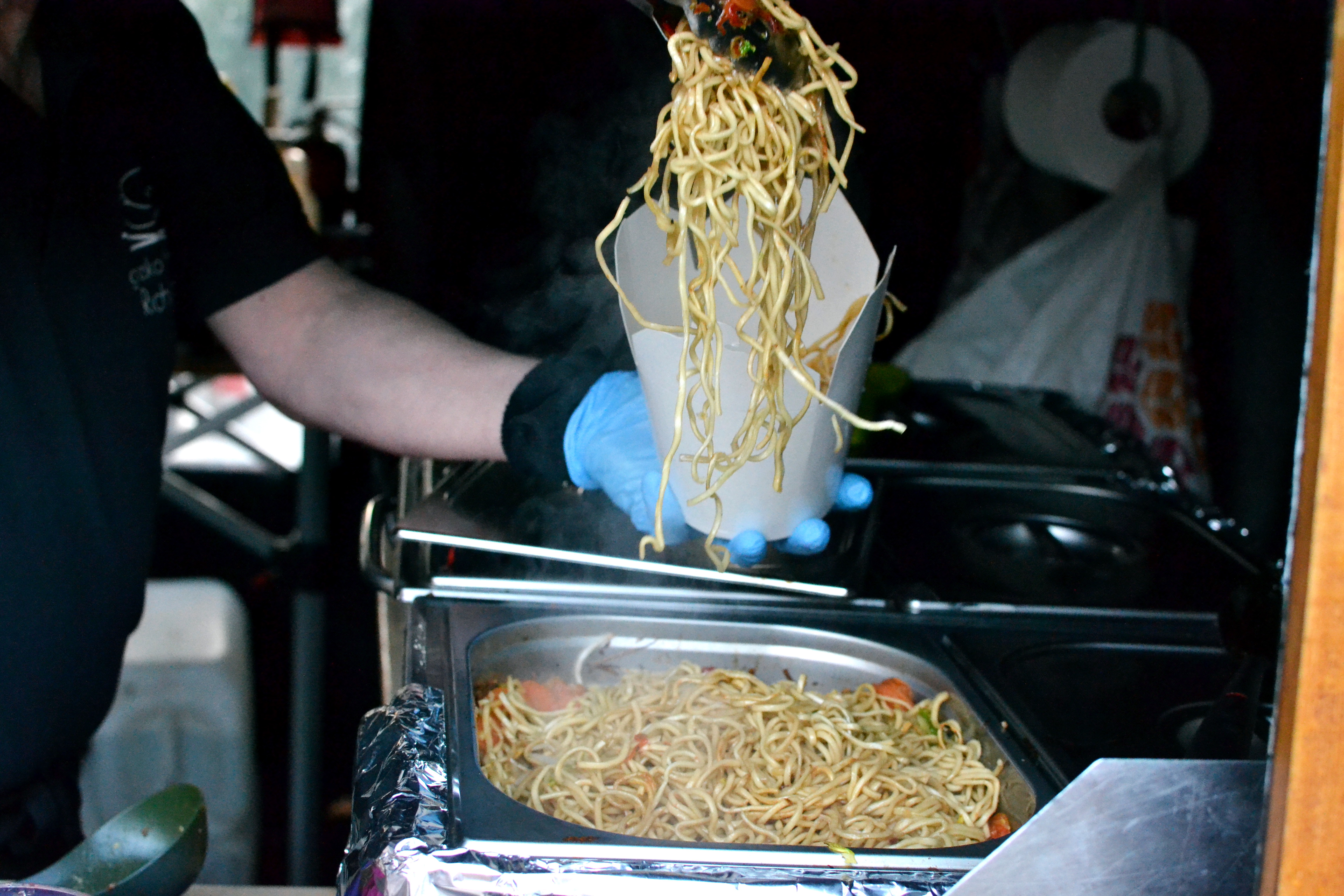 Serving noodles on the Gresko Bodhi stall