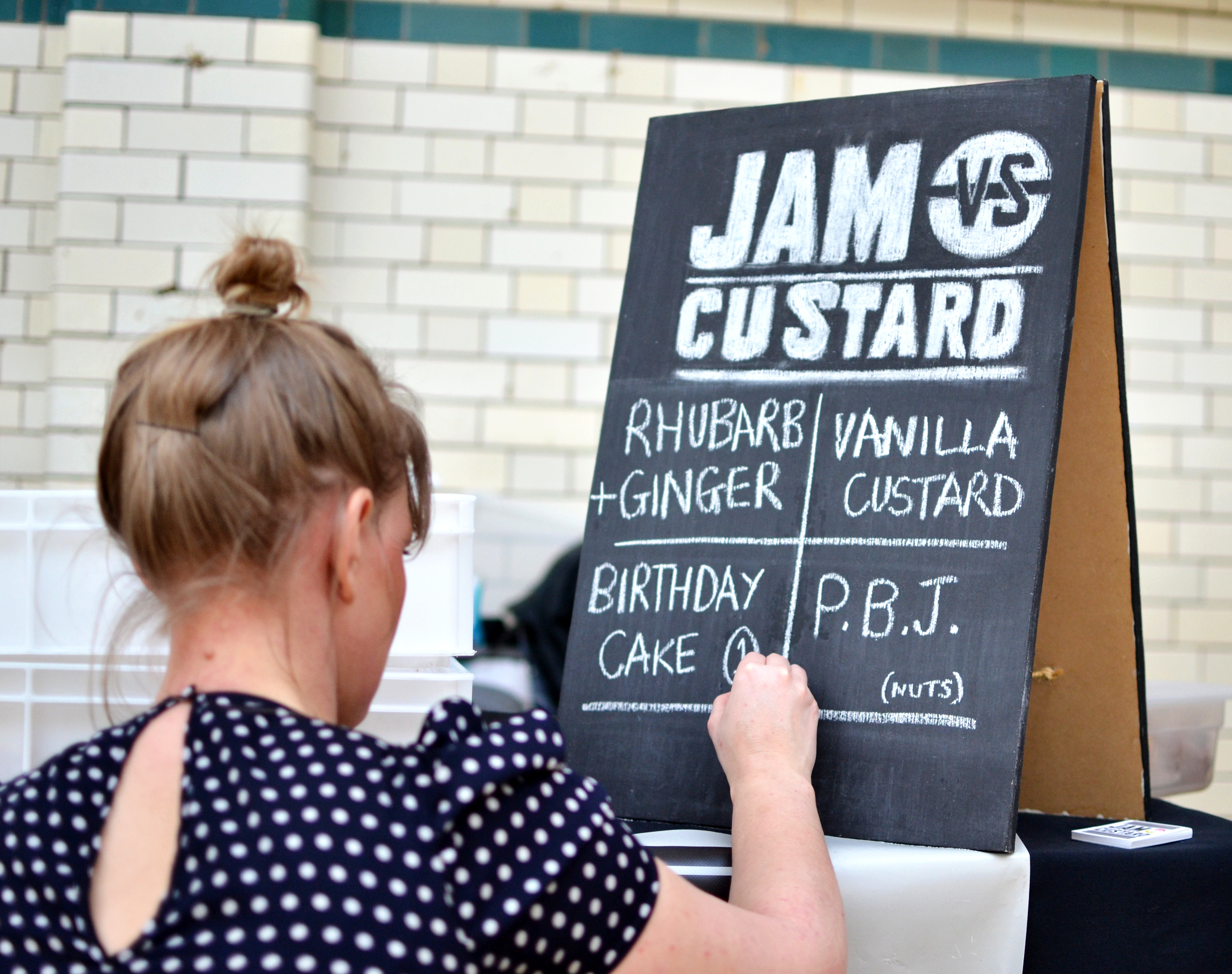 Writing today's doughnut flavours on a blackboard