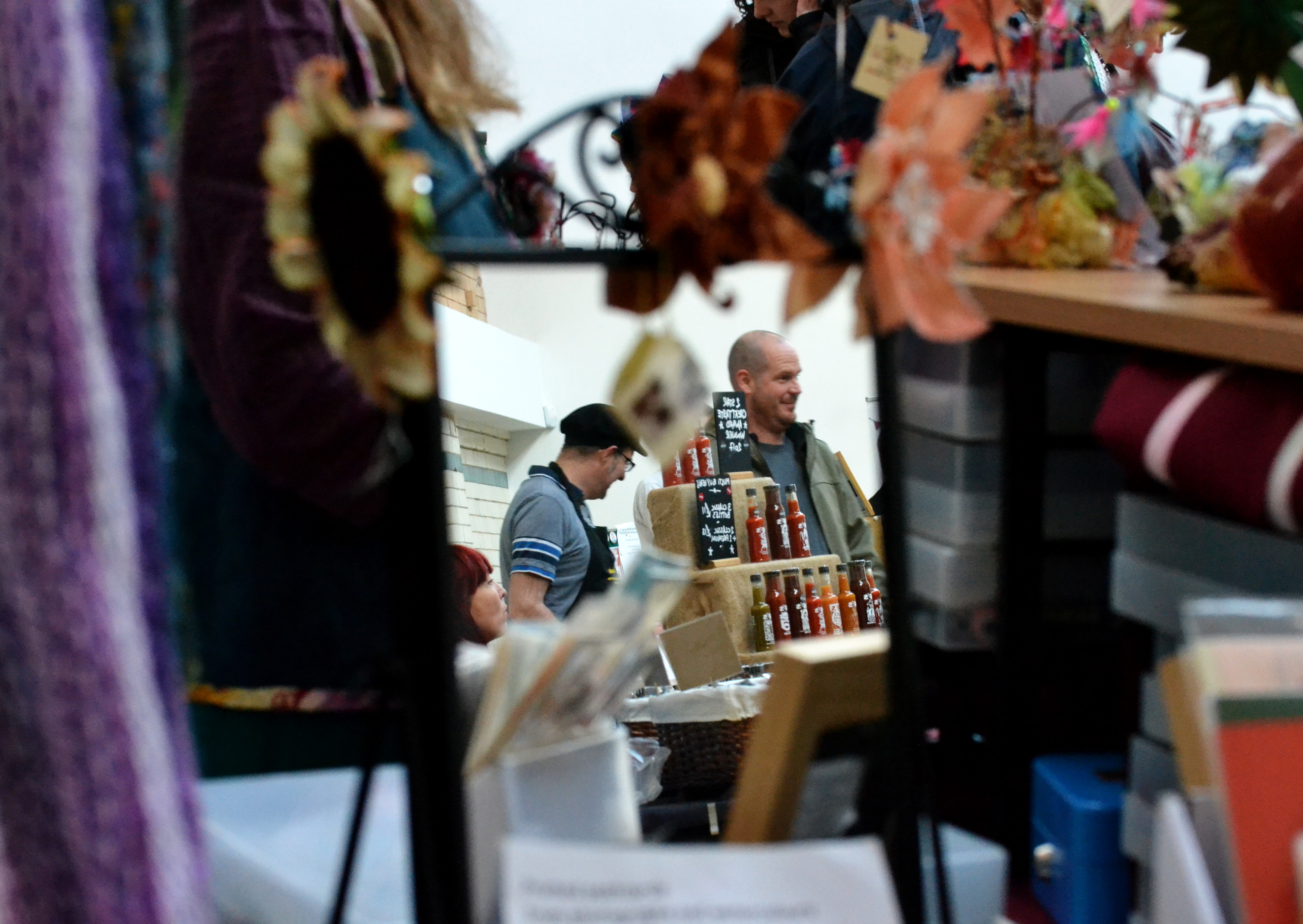 Reflection of the Market in a mirror on the Sarah Cage Textile Designs stall